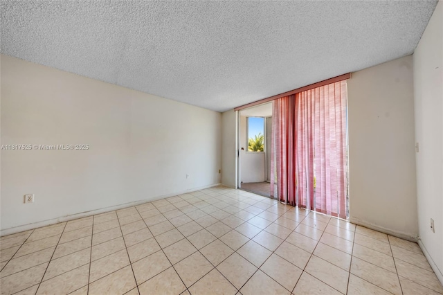 7921 Byron Ave Unit 407, Miami Beach, FL 33141 - spare room with a wall of windows, a textured ceiling, light tile patterned floors, and baseboards