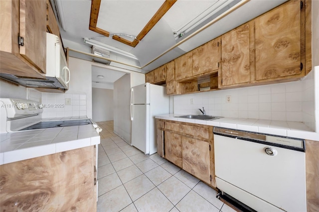 7921 Byron Ave Unit 407, Miami Beach, FL 33141 - kitchen featuring white appliances, tile countertops, a sink, and tasteful backsplash