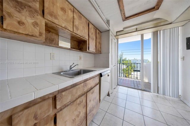 7921 Byron Ave Unit 407, Miami Beach, FL 33141 - kitchen with a sink, tile counters, decorative backsplash, light tile patterned flooring, and dishwasher