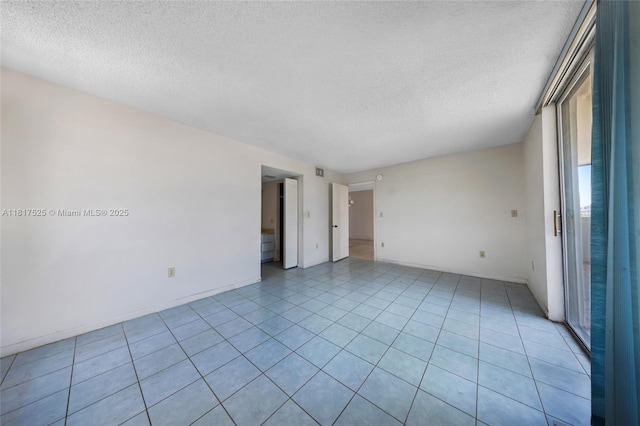 7921 Byron Ave Unit 407, Miami Beach, FL 33141 - empty room featuring a textured ceiling, baseboards, and light tile patterned floors
