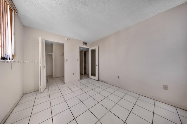 7921 Byron Ave Unit 407, Miami Beach, FL 33141 - unfurnished bedroom with a textured ceiling, a spacious closet, a closet, and baseboards