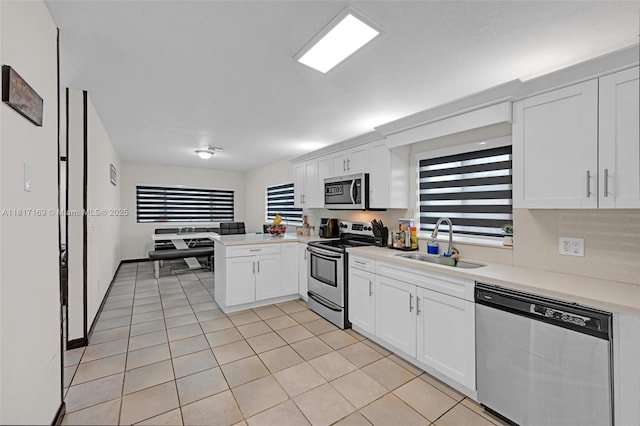 30930 SW 190th Ave, Homestead, FL 33030 - kitchen with appliances with stainless steel finishes, a sink, a peninsula, light countertops, and white cabinetry
