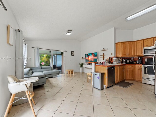 14358 SW 175th Ter, Miami, FL 33177 - kitchen with stainless steel appliances, vaulted ceiling, a peninsula, open floor plan, and a sink