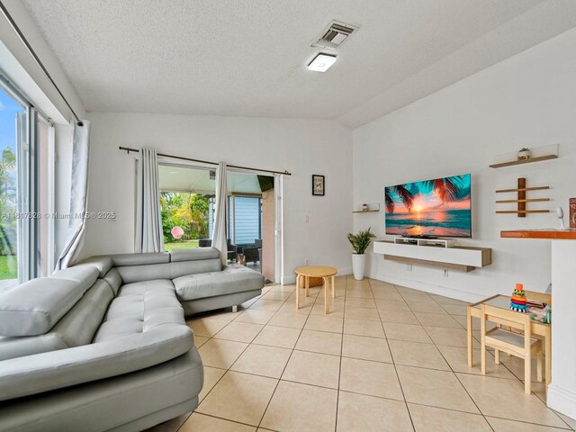14358 SW 175th Ter, Miami, FL 33177 - living area with vaulted ceiling, light tile patterned floors, healthy amount of natural light, and a textured ceiling