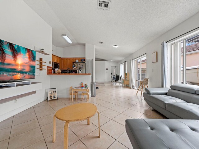 14358 SW 175th Ter, Miami, FL 33177 - living area with vaulted ceiling, light tile patterned floors, and a textured ceiling