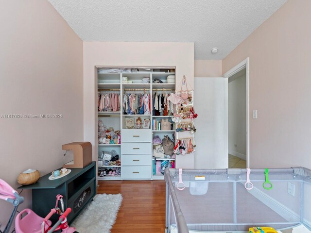 14358 SW 175th Ter, Miami, FL 33177 - bedroom featuring wood finished floors, a textured ceiling, and a closet