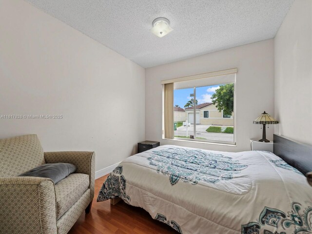 14358 SW 175th Ter, Miami, FL 33177 - bedroom featuring wood finished floors, baseboards, and a textured ceiling