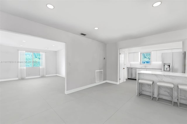 9401 SW 78th St, Miami, FL 33173 - kitchen with appliances with stainless steel finishes, white cabinets, recessed lighting, tasteful backsplash, and a kitchen breakfast bar