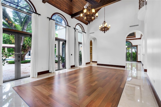 9801 SW 60th Ct, Pinecrest, FL 33156 - unfurnished living room featuring arched walkways, french doors, high vaulted ceiling, a chandelier, and baseboards