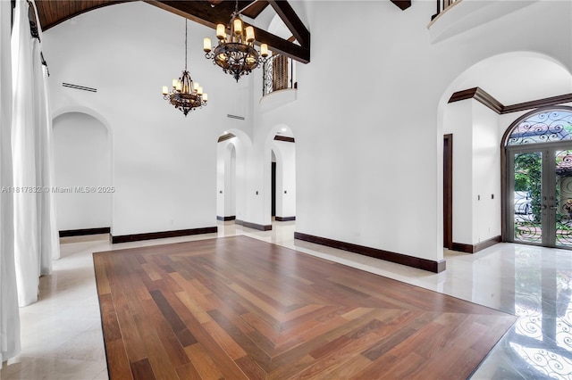 9801 SW 60th Ct, Pinecrest, FL 33156 - unfurnished living room with arched walkways, high vaulted ceiling, a chandelier, baseboards, and french doors