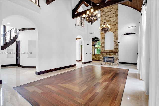 9801 SW 60th Ct, Pinecrest, FL 33156 - unfurnished living room with arched walkways, high vaulted ceiling, a chandelier, stairway, and beam ceiling