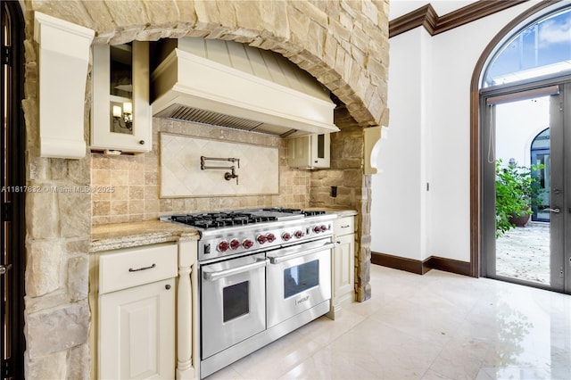 9801 SW 60th Ct, Pinecrest, FL 33156 - kitchen with double oven range, custom exhaust hood, backsplash, light stone countertops, and baseboards