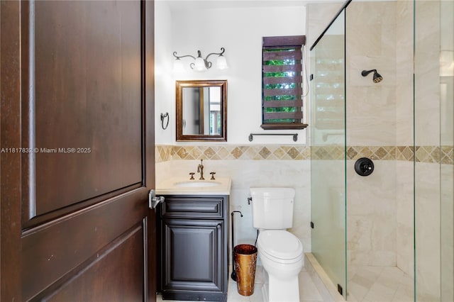 9801 SW 60th Ct, Pinecrest, FL 33156 - bathroom with a shower stall, toilet, vanity, tile walls, and a wainscoted wall
