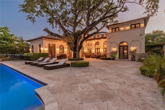 9801 SW 60th Ct, Pinecrest, FL 33156 - rear view of property featuring a patio, an outdoor pool, and stucco siding