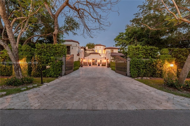 9801 SW 60th Ct, Pinecrest, FL 33156 - mediterranean / spanish-style house with a gate, stucco siding, and decorative driveway