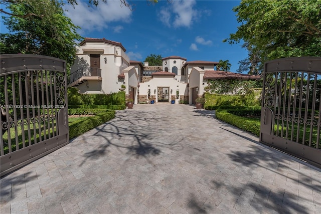 9801 SW 60th Ct, Pinecrest, FL 33156 - view of front of house with a gate, stucco siding, decorative driveway, and a tile roof