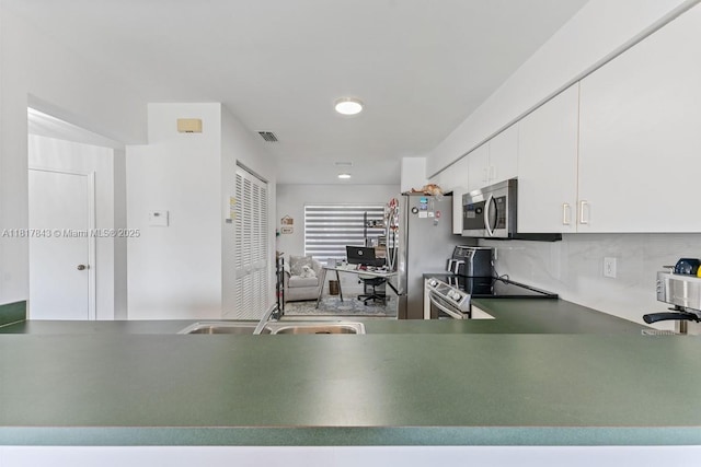 11045 SW 16th Mnr, Davie, FL 33324 - kitchen featuring stainless steel appliances, a sink, backsplash, and white cabinetry