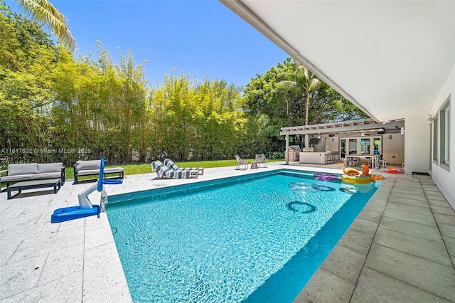 11001 SW 64th Ave, Pinecrest, FL 33156 - swimming pool with an outdoor hangout area, a patio area, and view of scattered trees