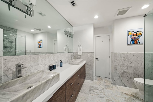 11001 SW 64th Ave, Pinecrest, FL 33156 - bathroom featuring tile walls, double vanity, a wainscoted wall, marble finish flooring, and recessed lighting