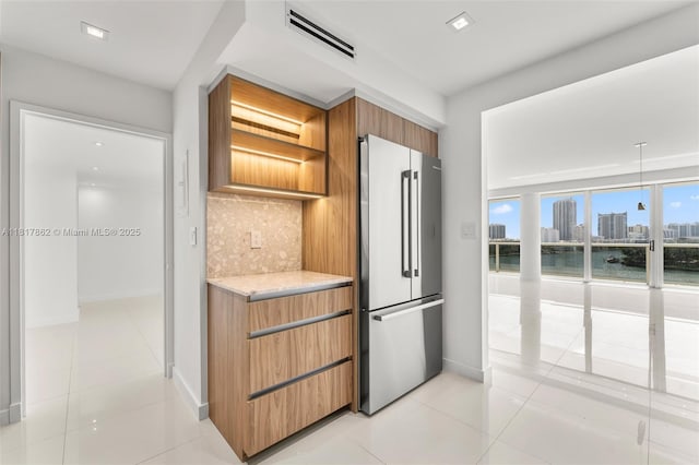 900 Bay Dr Unit 904, Miami Beach, FL 33141 - kitchen featuring freestanding refrigerator, decorative backsplash, baseboards, modern cabinets, and light tile patterned flooring
