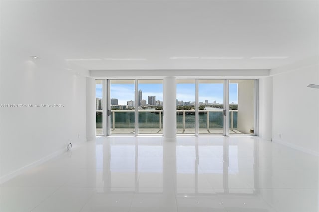 900 Bay Dr Unit 904, Miami Beach, FL 33141 - empty room with tile patterned floors, baseboards, healthy amount of natural light, and a skyline view