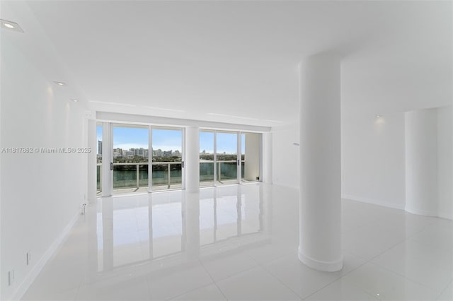 900 Bay Dr Unit 904, Miami Beach, FL 33141 - tiled empty room featuring a water view and baseboards