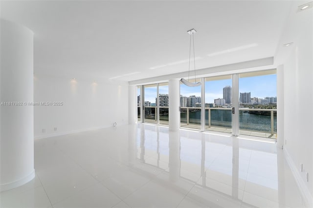 900 Bay Dr Unit 904, Miami Beach, FL 33141 - unfurnished room featuring a city view, light tile patterned flooring, a water view, and baseboards
