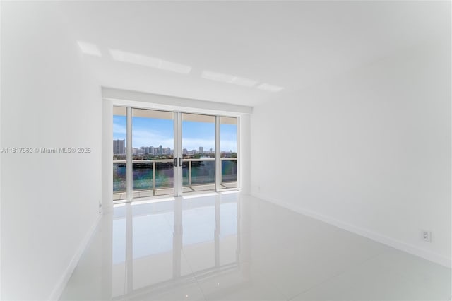 900 Bay Dr Unit 904, Miami Beach, FL 33141 - tiled empty room featuring a water view, baseboards, and a city view