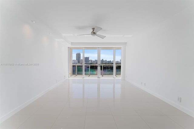 900 Bay Dr Unit 904, Miami Beach, FL 33141 - empty room featuring ceiling fan, baseboards, a skyline view, and tile patterned flooring