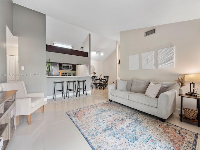 10421 SW 157th Pl Unit 301, Miami, FL 33196 - tiled living area featuring high vaulted ceiling, baseboards, and track lighting
