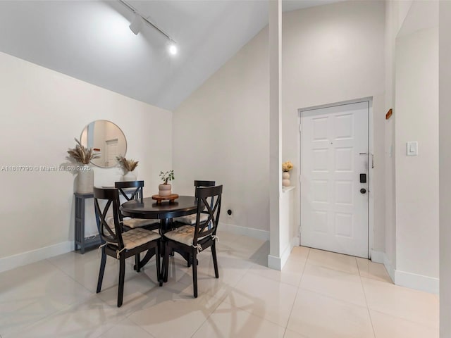 10421 SW 157th Pl Unit 301, Miami, FL 33196 - dining area with track lighting, high vaulted ceiling, baseboards, and light tile patterned floors
