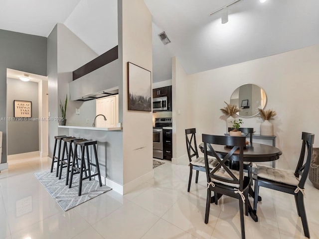 10421 SW 157th Pl Unit 301, Miami, FL 33196 - dining space featuring high vaulted ceiling, rail lighting, light tile patterned floors, and baseboards