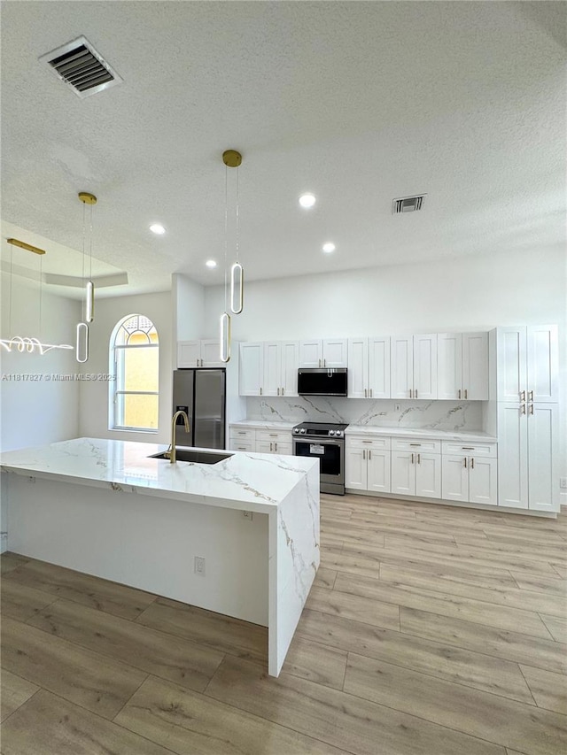 7020 Demedici Cir, Delray Beach, FL 33446 - kitchen with appliances with stainless steel finishes, light wood-style flooring, white cabinets, recessed lighting, and light stone counters