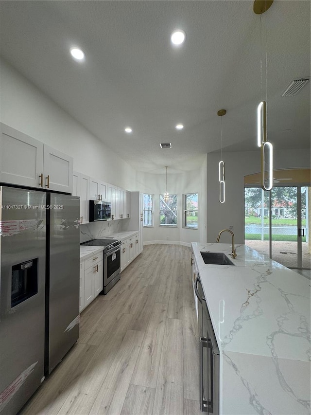 7020 Demedici Cir, Delray Beach, FL 33446 - kitchen featuring stainless steel appliances, recessed lighting, light wood-type flooring, light stone countertops, and decorative light fixtures
