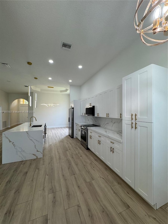 7020 Demedici Cir, Delray Beach, FL 33446 - kitchen featuring stainless steel appliances, white cabinetry, light wood-style floors, a chandelier, and recessed lighting