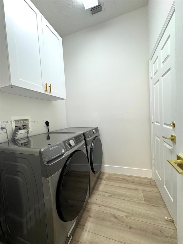 7020 Demedici Cir, Delray Beach, FL 33446 - laundry area with cabinet space, light wood-type flooring, and washing machine and dryer