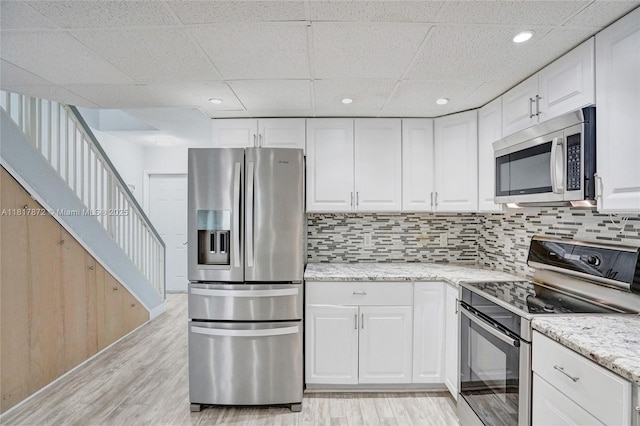 1449 NW 122nd Ter, Pembroke Pines, FL 33026 - kitchen with stainless steel appliances, light wood finished floors, white cabinetry, a paneled ceiling, and recessed lighting