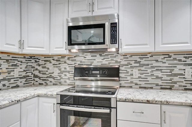 1449 NW 122nd Ter, Pembroke Pines, FL 33026 - kitchen featuring stainless steel appliances, white cabinets, decorative backsplash, and light stone counters