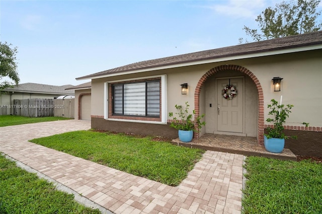 13317 NW 8th Ct, Sunrise, FL 33325 - property entrance featuring stucco siding, driveway, and a yard