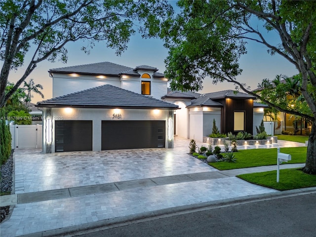 3461 SW 145th Ave, Miramar, FL 33027 - view of front facade featuring decorative driveway, an attached garage, a tiled roof, a yard, and a gate