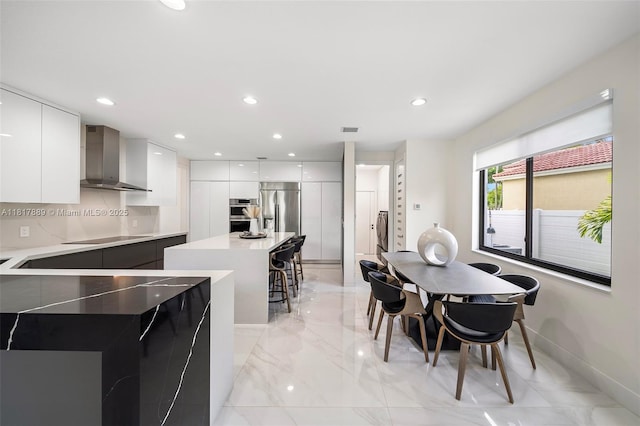 3461 SW 145th Ave, Miramar, FL 33027 - kitchen with modern cabinets, wall chimney range hood, stainless steel appliances, a center island, and white cabinetry