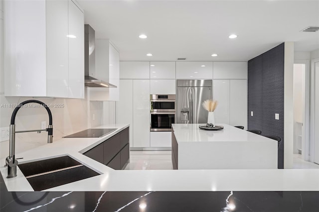 3461 SW 145th Ave, Miramar, FL 33027 - kitchen featuring modern cabinets, stainless steel appliances, white cabinets, wall chimney range hood, and a sink