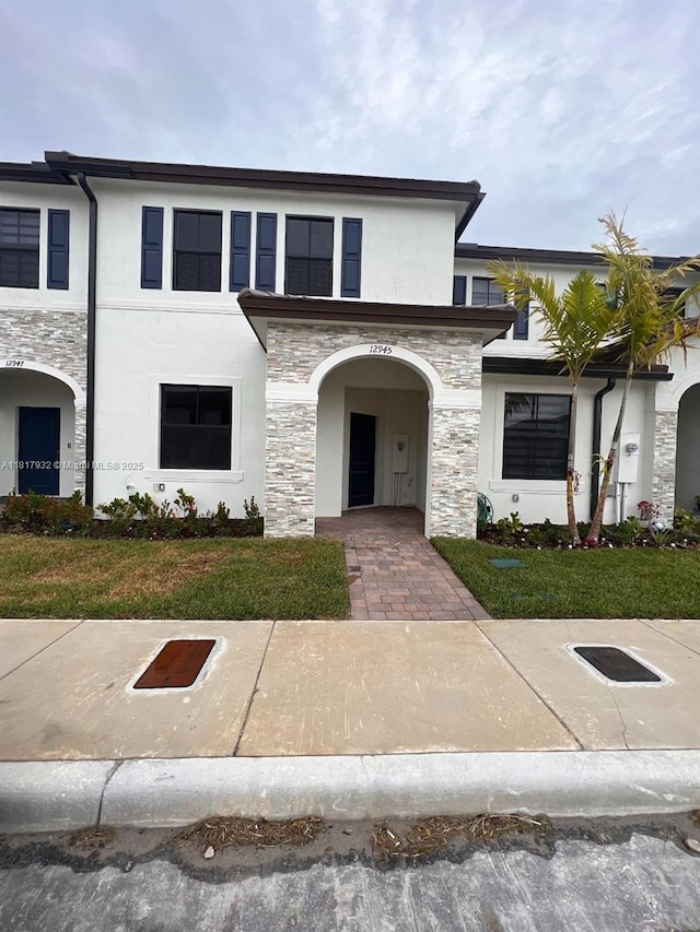 12945 SW 232nd Ln, Homestead, FL 33032 - view of front of property with stone siding, stucco siding, and a front yard
