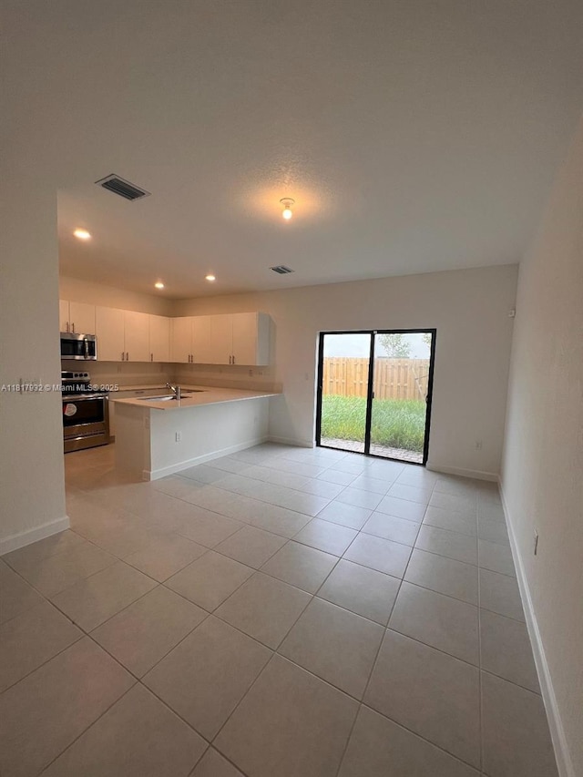 12945 SW 232nd Ln, Homestead, FL 33032 - kitchen featuring appliances with stainless steel finishes, light countertops, open floor plan, light tile patterned flooring, and recessed lighting
