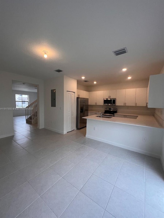 12945 SW 232nd Ln, Homestead, FL 33032 - kitchen featuring appliances with stainless steel finishes, light tile patterned flooring, light countertops, electric panel, and white cabinets