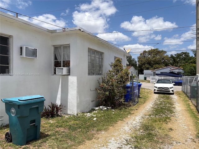 3072 SW 16th St, Miami, FL 33145 - view of home's exterior with stucco siding, cooling unit, an AC wall unit, and crawl space