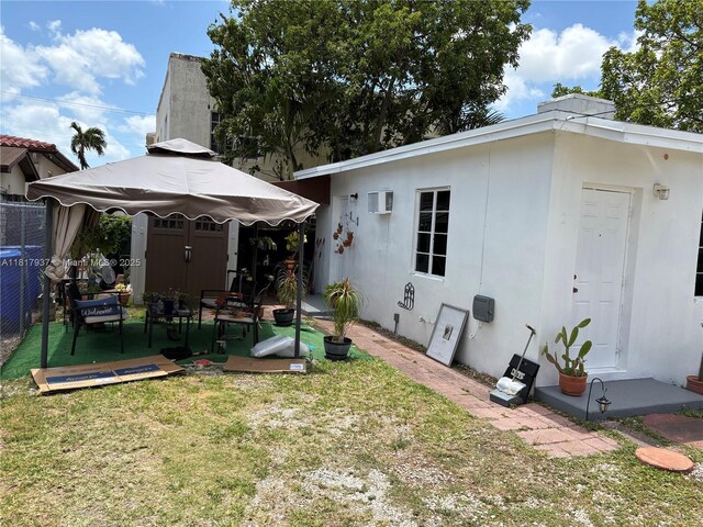 3072 SW 16th St, Miami, FL 33145 - rear view of house with a wall mounted AC, a gazebo, and stucco siding