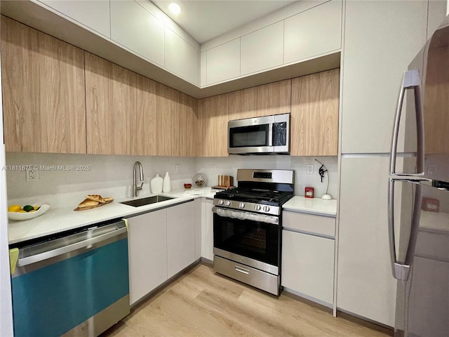 1619 Jefferson Ave Unit 23, Miami Beach, FL 33139 - kitchen with stainless steel appliances, a sink, light countertops, and light wood-type flooring