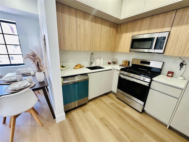 1619 Jefferson Ave Unit 23, Miami Beach, FL 33139 - kitchen featuring stainless steel appliances, a sink, light countertops, and light wood finished floors