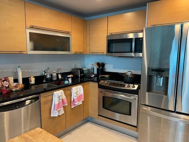 950 Brickell Bay Dr Unit 1608, Miami, FL 33131 - kitchen featuring appliances with stainless steel finishes, light tile patterned floors, and dark countertops
